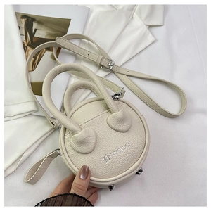 Detailed view of white circular mini crossbody bag with litchi texture and metal studs