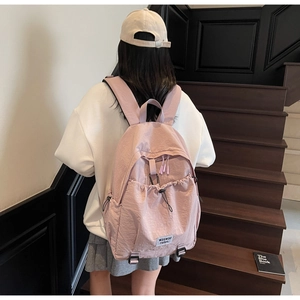 Detail of Morandi pink backpack with drawstring pocket and waswac rules woven label