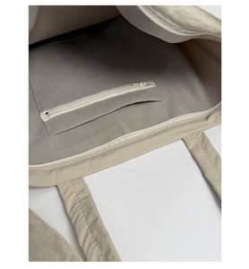 Detail view of large canvas tote bag showing herringbone lining and internal zip pocket