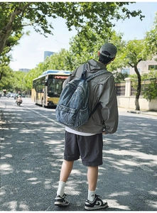 Outdoor street view of a retro light blue denim backpack with washed texture details