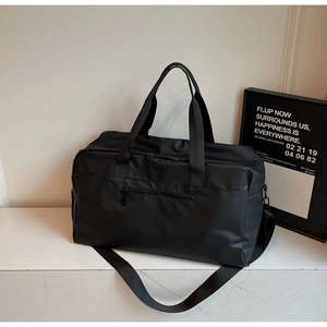Dettaglio del tessuto in nylon nero impermeabile su una grande borsa sportiva da viaggio