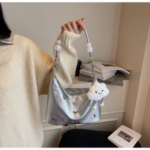 Détail d'un sac en cuir argenté avec papillons en métal et pendentif nuage