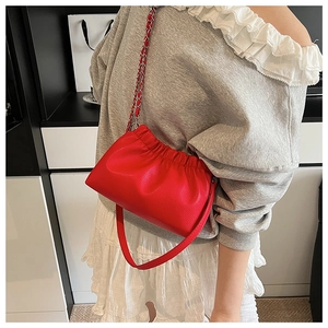 Dettaglio della borsa a nuvola in pelle rossa con design arricciato e tracolla a catena