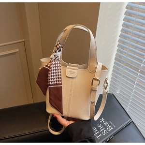 Detail of off-white bucket bag with houndstooth silk scarf and fashion text on leather