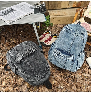 Detailed outdoor view of retro washed denim backpacks in carbon gray and blue