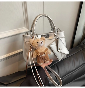 Détail du sac cabas argenté avec breloque ours et pochette enveloppe accessoire