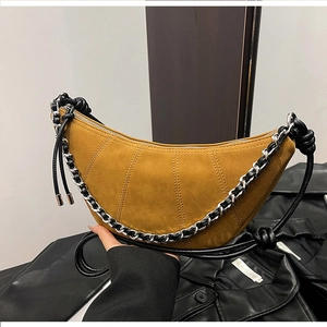Detail of yellow suede croissant bag with silver chain and knotted leather strap