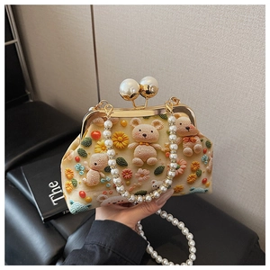 Close-up of crochet embroidery shell bag with floral sunflower details and pearl clasp