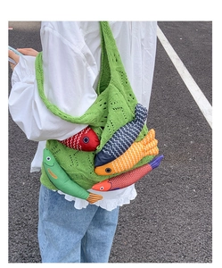 Detail of green knit tote bag featuring colorful handmade 3D fish doll ornaments