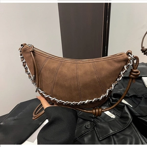 Detail of coffee brown suede crescent bag with vertical stitching and silver chain