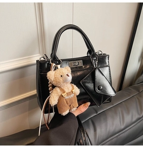 Détail du sac cabas noir avec fermoir tournant argenté et charmant ours en peluche