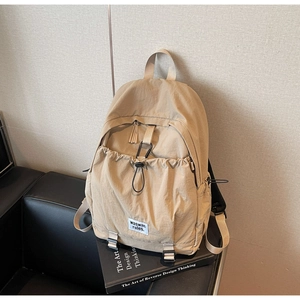 Detail of khaki nylon backpack featuring texture and waswac rules lettering patch
