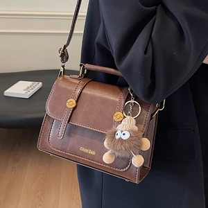 Vintage dark brown crossbody bag with plush charm and stylish buckle straps decoration