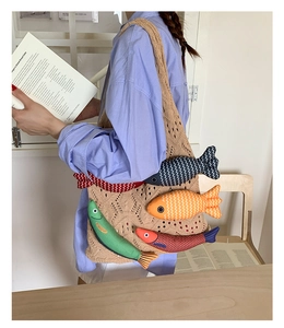 Detail of beige crochet knit tote bag with colorful 3D stuffed fish charm decorations
