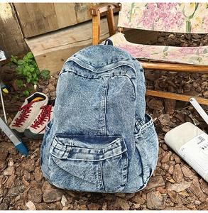 Macro view of washed blue denim backpack fabric with vintage faded texture details