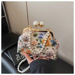 Detail of vintage shell bag featuring 3D teddy bear floral knit and pearl bead handle