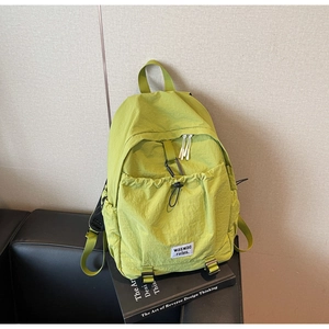Detail view of light green waterproof nylon backpack with climbing buckle and drawstring