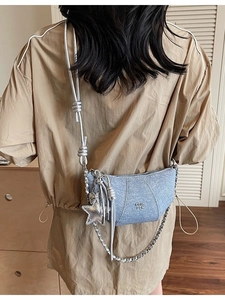 Light blue denim texture crossbody bag with silver chain strap and star pendant