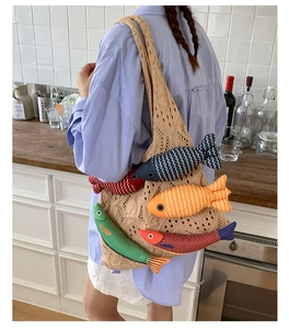 Detail of a beige knit mesh tote bag featuring five colorful handcrafted fish charms