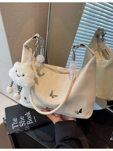 Sac hobo beige avec breloques papillon argentées et porte-clés nuage en peluche