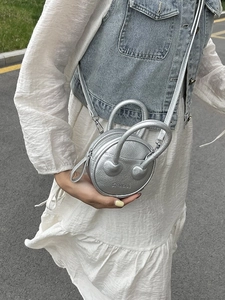 Silver metallic round mini crossbody bag with textured leather and adjustable strap