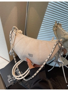 Minimalist white croissant bag with silver chain strap and star charm accessory