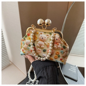 Detail of crochet teddy bear and floral patterns on bag with pearl bead handle