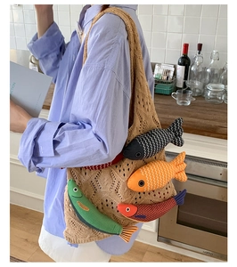 Detail of hand-knitted tote bag featuring colorful 3D fish embroidery and soft texture