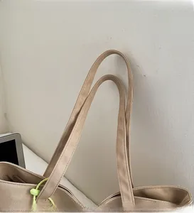 Dettaglio della doppia cucitura rinforzata sui manici della borsa tote in tela beige