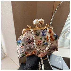 Detail of vintage shell bag showing pearl clasp, chain handle and bear knit pattern