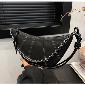 Detail of black crescent crossbody bag with white contrast stitching and silver chain