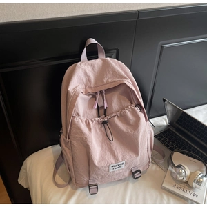 Detail of pink-purple nylon backpack with drawstring pocket and secure buckles
