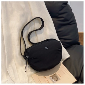 Detail of black nylon crossbody bag with silver logo and adjustable wide strap