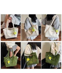 Dettaglio della borsa tote in tela con ciondolo a girasole e struttura della tracolla