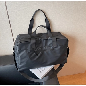 Dettaglio della borsa da viaggio nera con cinghie resistenti e tessuto in nylon