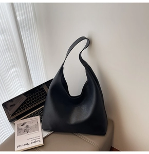 Primo piano dettagliato della trama in pelle nera con motivo litchi della borsa Hobo chic