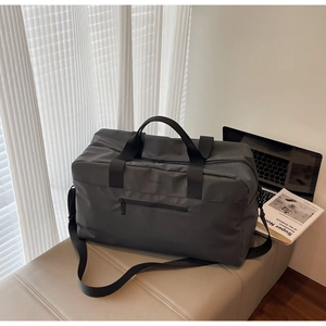 Dettaglio della borsa da viaggio grigio scuro con tessuto opaco e tracolla regolabile