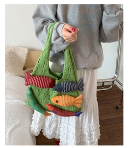 Detail of green knit tote bag with colorful 3D plush fish pendants for casual vacation