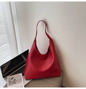Dettaglio borsa tote in pelle martellata rossa con texture morbida e tracolla larga