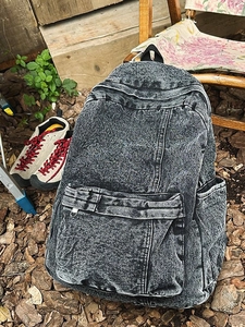 Retro grey acid wash denim backpack with multiple pockets and durable canvas texture