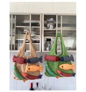 Detail of hand-knitted crochet tote bags featuring colorful 3D fish appliques and textures