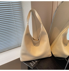 Dettaglio della borsa tote beige in pelle con trama a litchi dallo stile minimalista