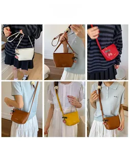 Minimalistische Umhängetaschen in verschiedenen Farben mit Kirschanhänger am Modell