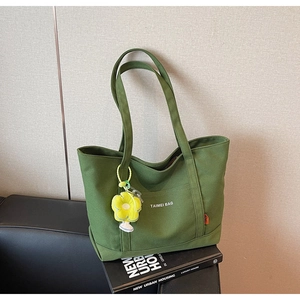 Dettaglio borsa shopper in tela verde oliva con logo TAIMEI e ciondolo a girasole