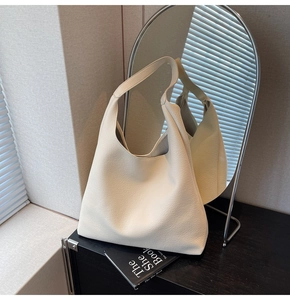 Dettaglio della borsa hobo in pelle martellata bianco crema con ombre di luce naturale