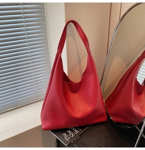 Dettaglio della trama in pelle rossa con motivo litchi su una grande borsa hobo