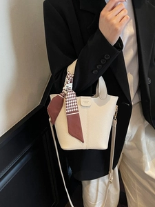 Minimalist beige bucket bag with houndstooth silk scarf handle and leather texture