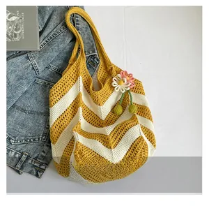 Macro detail of wave-patterned knit tote bag with 3D floral charm and soft cotton texture