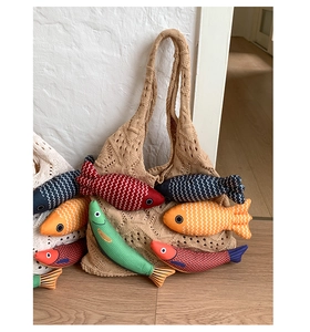 Detail of khaki knit tote bag with colorful handmade fish-shaped plush charms