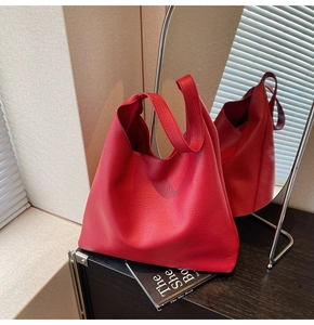 Dettaglio macro della pelle martellata rossa sulla grande borsa tote con tracolla